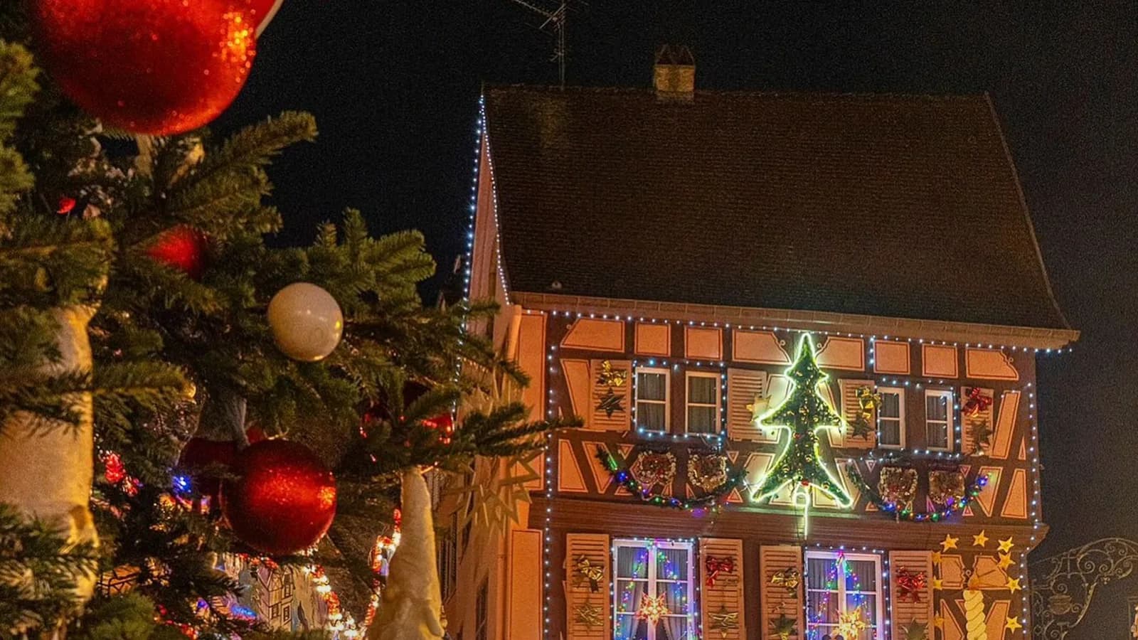 Casa enfeitada com luzes de Natal e árvore decorada em um mercado de Natal na Europa